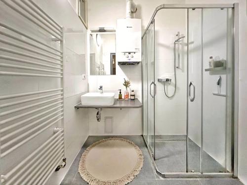 a bathroom with a sink and a shower at Bright and central suite with a balcony in Brno