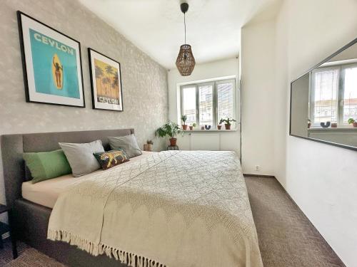 um quarto com uma cama e duas janelas em Bright and central suite with a balcony em Brno