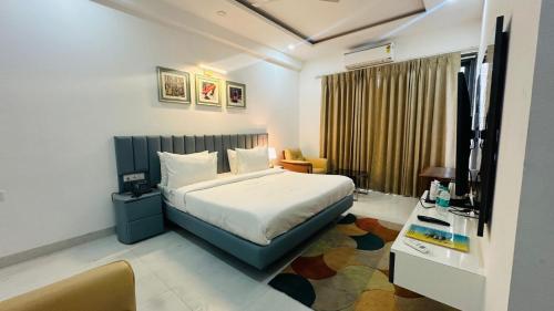 Habitación de hotel con cama y escritorio en Elite 32 Avenue - Near Google Building en Gurgaon