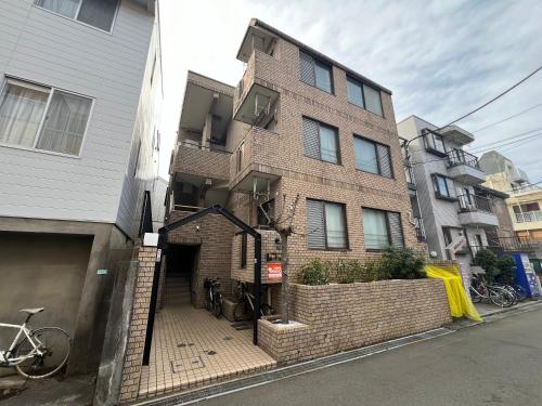 Naka-tomiにあるAkazu-hostel newのレンガ造りの建物で、自転車がその前に駐車されています。