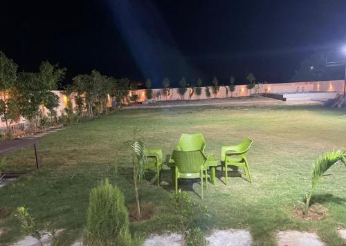 a group of green chairs in a field at night at Ramaniya Jaisalmer in Jaipur