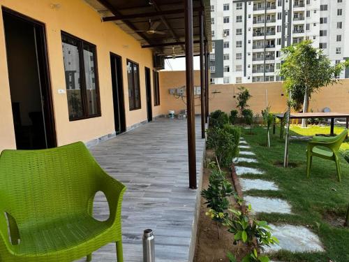 a patio with green chairs and a building at Ramaniya Jaisalmer in Jaipur