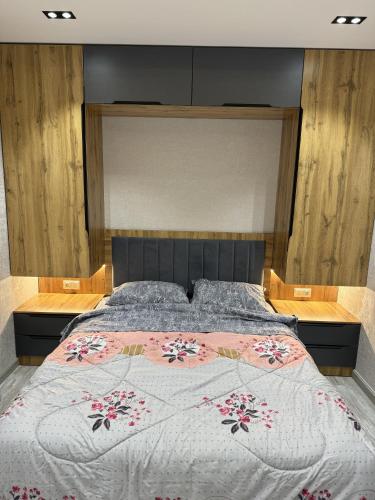 een slaapkamer met een groot bed met een sprei met bloemen bij New apartment in Yunusobod dist. in Tasjkent