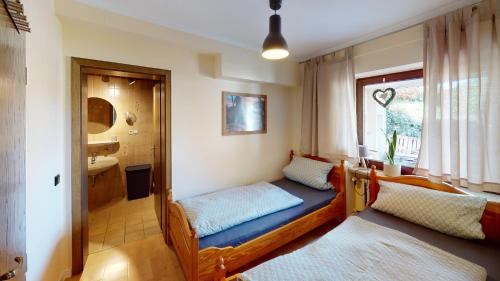 1 dormitorio con 2 camas y ventana en Ferienappartement WildeAhr, en Rech