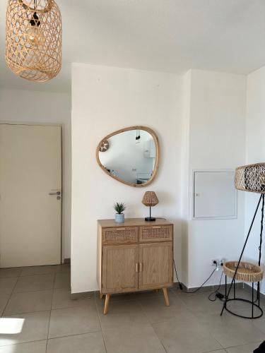 Cette chambre comprend une commode en bois et un miroir. dans l'établissement Porto vecchio Résidence Don Andria T2, à Lecci