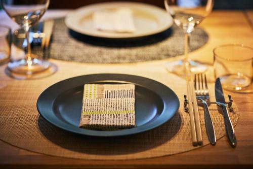 a table set with a blue plate and fork and knife at Auberge AZABU in Kyoto