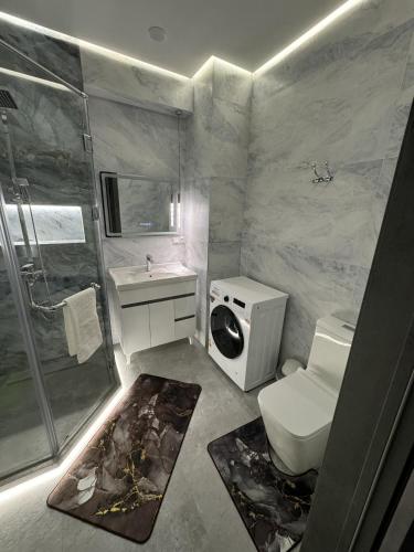 een badkamer met een douche, een toilet en een wastafel bij New apartment in Yunusobod dist. in Tasjkent