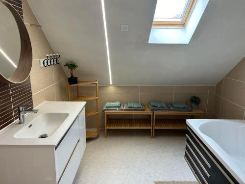 ein Bad mit einem Waschbecken, einer Badewanne und einem Fenster in der Unterkunft La maison du chêne in Chaignay
