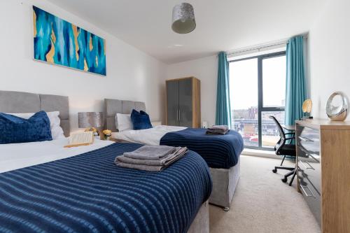 a bedroom with two beds and a desk and a window at Stevenage - 2 Bedroom Apartment, Free Wifi & Balcony Upto 5 guests in Stevenage