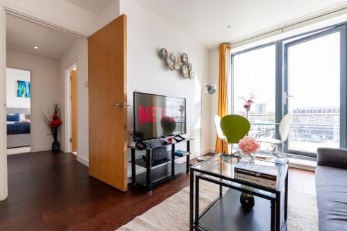 a living room with a couch and a tv at Stevenage - 2 Bedroom Apartment, Free Wifi & Balcony Upto 5 guests in Stevenage