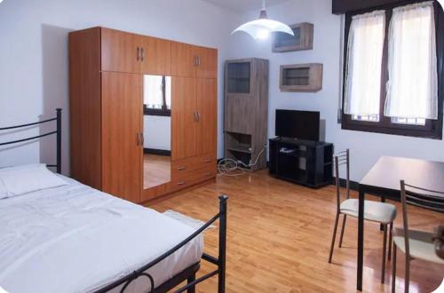 - une chambre avec un lit, une armoire et une table dans l'établissement Condominio pelusia, à Modène