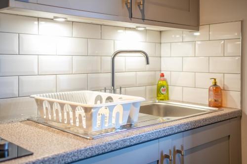 a kitchen sink with a dish drying rack on the counter at MSRSH lux 5 in Manchester