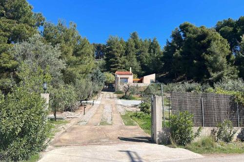 een onverharde weg met een hek en een huis bij Askalosia villa in Agios Georgios