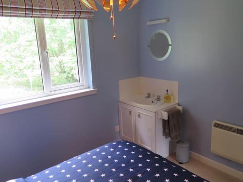 a bathroom with a bed and a sink and a window at Stella Mara Cottage in Aultbea