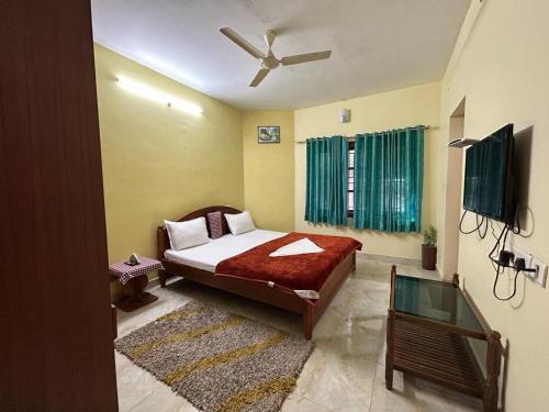 um quarto com uma cama e uma ventoinha de tecto em Madhu Manish Homestay and Rooms em Coonoor