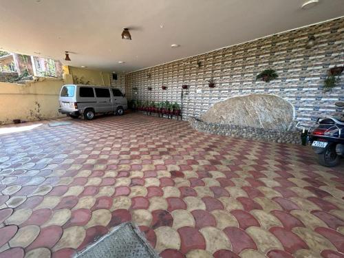 a garage with a brick wall and a car parked at Madhu Manish Homestay and Rooms in Coonoor