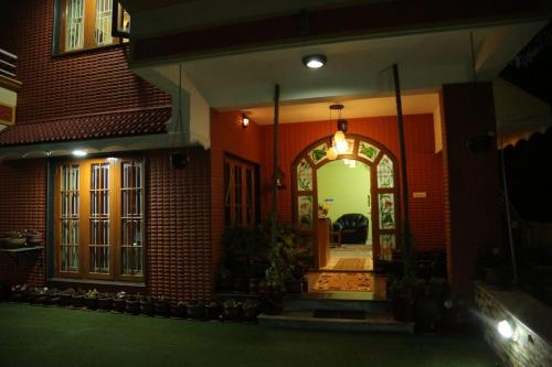 a house with an archway in the front of it at Madhu Manish Homestay and Rooms in Coonoor