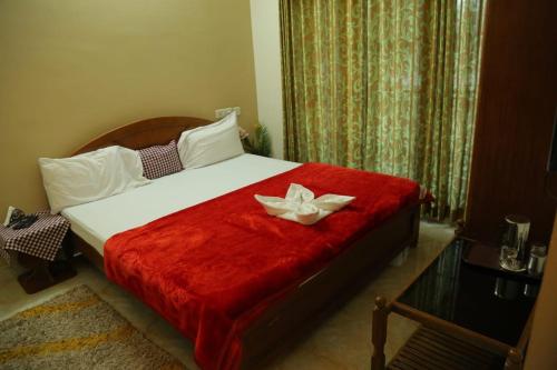 a bedroom with a bed with a flower on it at Madhu Manish Homestay and Rooms in Coonoor