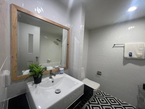 Baño blanco con lavabo y espejo en 1Bedroom,ayuttya,swimming pool,Garden Access en Ban Ko Rian