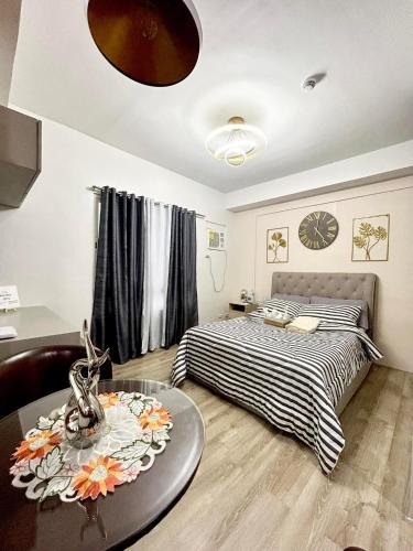 Un dormitorio con 2 camas y una mesa con flores. en KeikaCondo BCD, en Bacolod