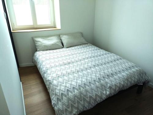 un lit dans une petite pièce avec une fenêtre dans l'établissement Appartement proche centre-ville, à Langogne