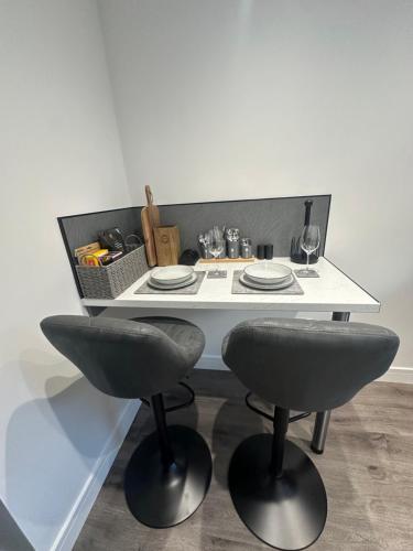 a white table with two chairs and a basket of food at Burnbrae Apartment in Portree