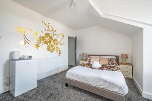 a white bedroom with a bed with a gold design on the wall at *RB246* For your most relaxed & Cosy stay + Free Parking + Free Fast WiFi * in Knowsthorpe