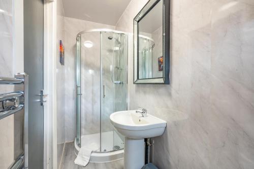 a white bathroom with a sink and a shower at *RB246* For your most relaxed & Cosy stay + Free Parking + Free Fast WiFi * in Knowsthorpe
