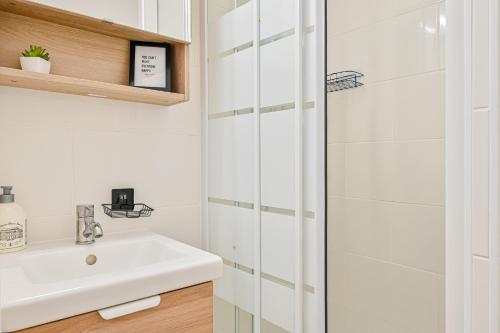 ein weißes Badezimmer mit Waschbecken und Dusche in der Unterkunft Le CozyBussy - 4 pers - Disney & Paris - Parking in Bussy-Saint-Georges