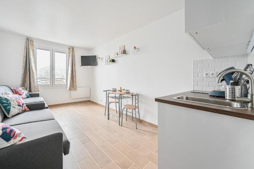 une cuisine et un salon avec un canapé et une table dans l'établissement Le CozyBussy - 4 pers - Disney & Paris - Parking, à Bussy-Saint-Georges