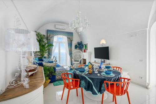a dining room with a table with red chairs at Villa Navarra in Praiano