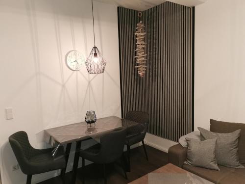 uma sala de jantar com mesa e cadeiras e um relógio em Ferienwohnung Steffens - "Wicheldorfstraße" em Grömitz