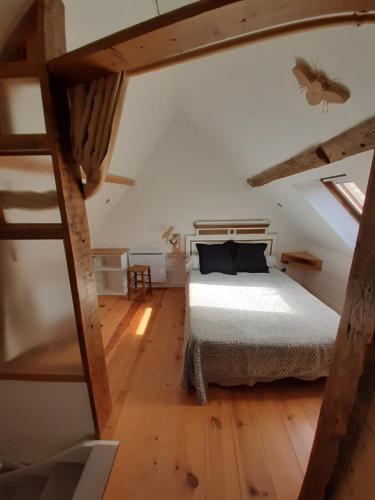 een slaapkamer met een bed op zolder bij Le gîte des pierres in Nogent-le-Rotrou