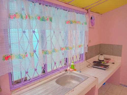 een kamer met een raam met een wastafel bij Gooday homestay in Skudai