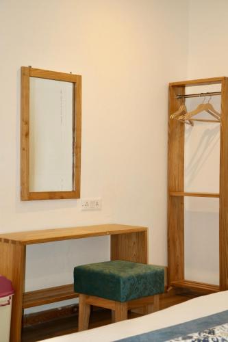 a bedroom with a table and a mirror at Hotel Palam Hills in Leh