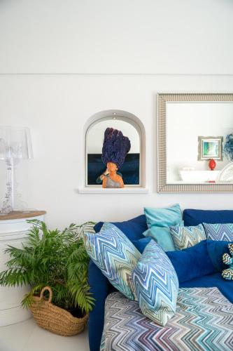 a living room with a blue couch and a mirror at Villa Navarra in Praiano