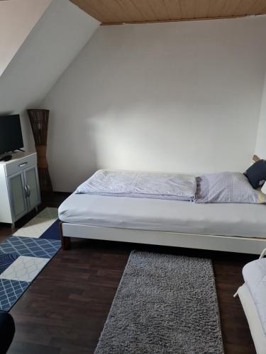 a bedroom with a bed and a dresser with a television at Ferienwohnung Bluhm Wahlstedt 