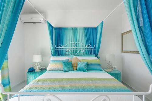 a bedroom with a blue canopy bed with blue curtains at Villa Navarra in Praiano
