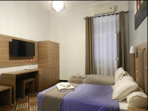 a hotel room with two beds and a television at SAMIR HOTEL in Alger