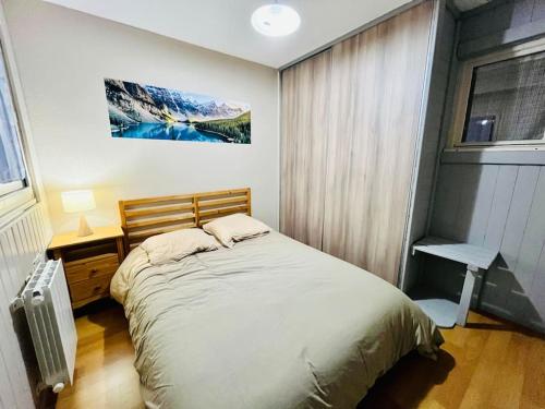 a bedroom with a large bed and a window at Appartement T3 Allemond in Allemont