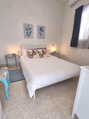 - une chambre avec un grand lit blanc et 2 tables dans l'établissement Ground floor apartment 3 min walk from the sea, à Marsaskala