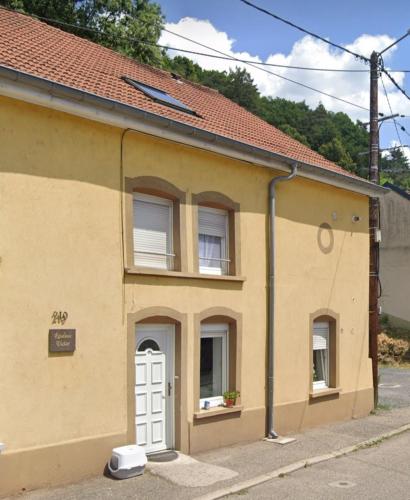 a yellow building with a white door at L équinoxe in Abreschviller