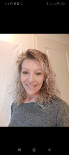 a woman with curly hair smiling at the camera at L équinoxe in Abreschviller