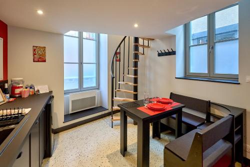 une cuisine et une salle à manger avec une table et un escalier dans l'établissement Studio ciné atypique Climatisé à Nevers by Primo Conciergerie, à Nevers