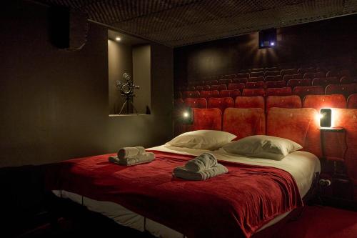 ヌヴェールにあるStudio ciné atypique Climatisé à Nevers by Primo Conciergerieのベッドルーム1室(ベッド1台、帽子2つ付)