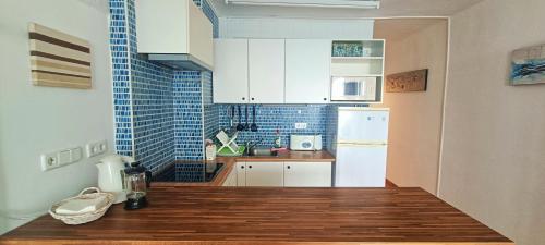 a kitchen with a white refrigerator and a wooden floor at Mediterranean sea view apartment in Santa Ponsa