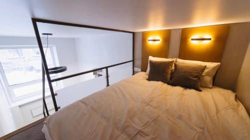 a bedroom with a bed with two pillows and a window at City Apartments in Tallinn