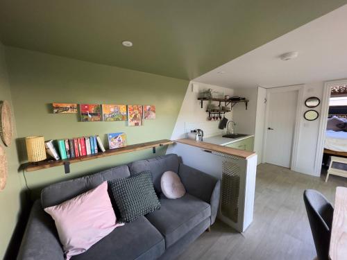 a living room with a couch and a kitchen at The Snug: Dorset hideaway in Blandford Forum