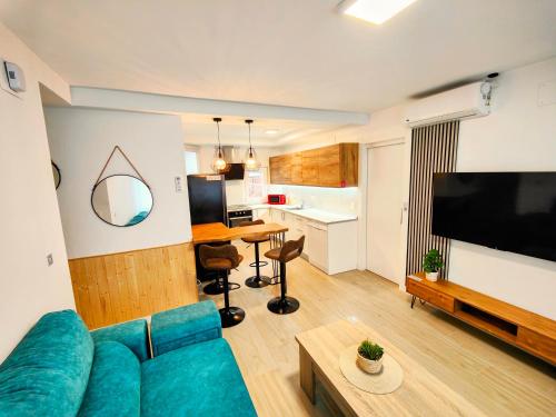 a living room with a blue couch and a kitchen at El Andén de Garrido (sin ascensor) in Salamanca