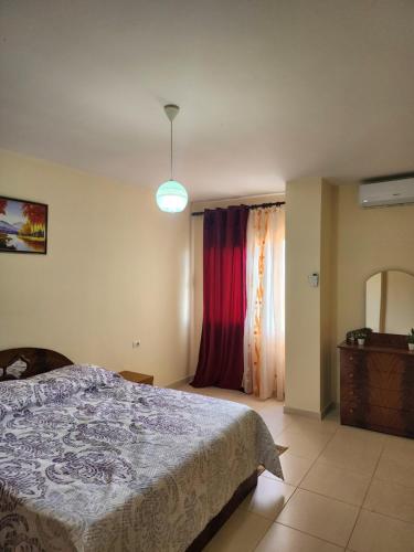 een slaapkamer met een bed, een raam en een licht bij Lucky's apartment, a place to be in Pogradec
